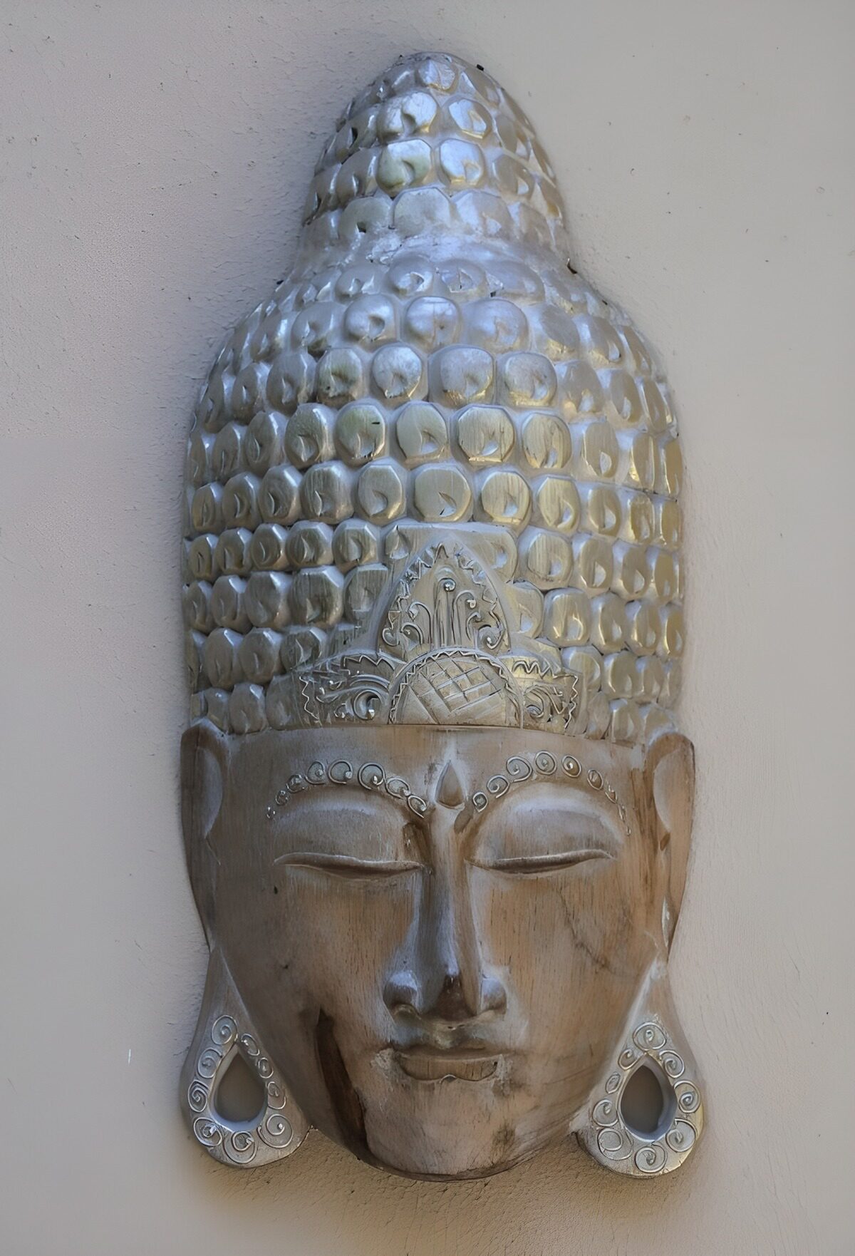 Carved wooden Buddha face in soft light