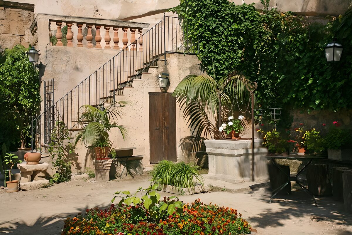 Sunlit courtyard with flowers and a well