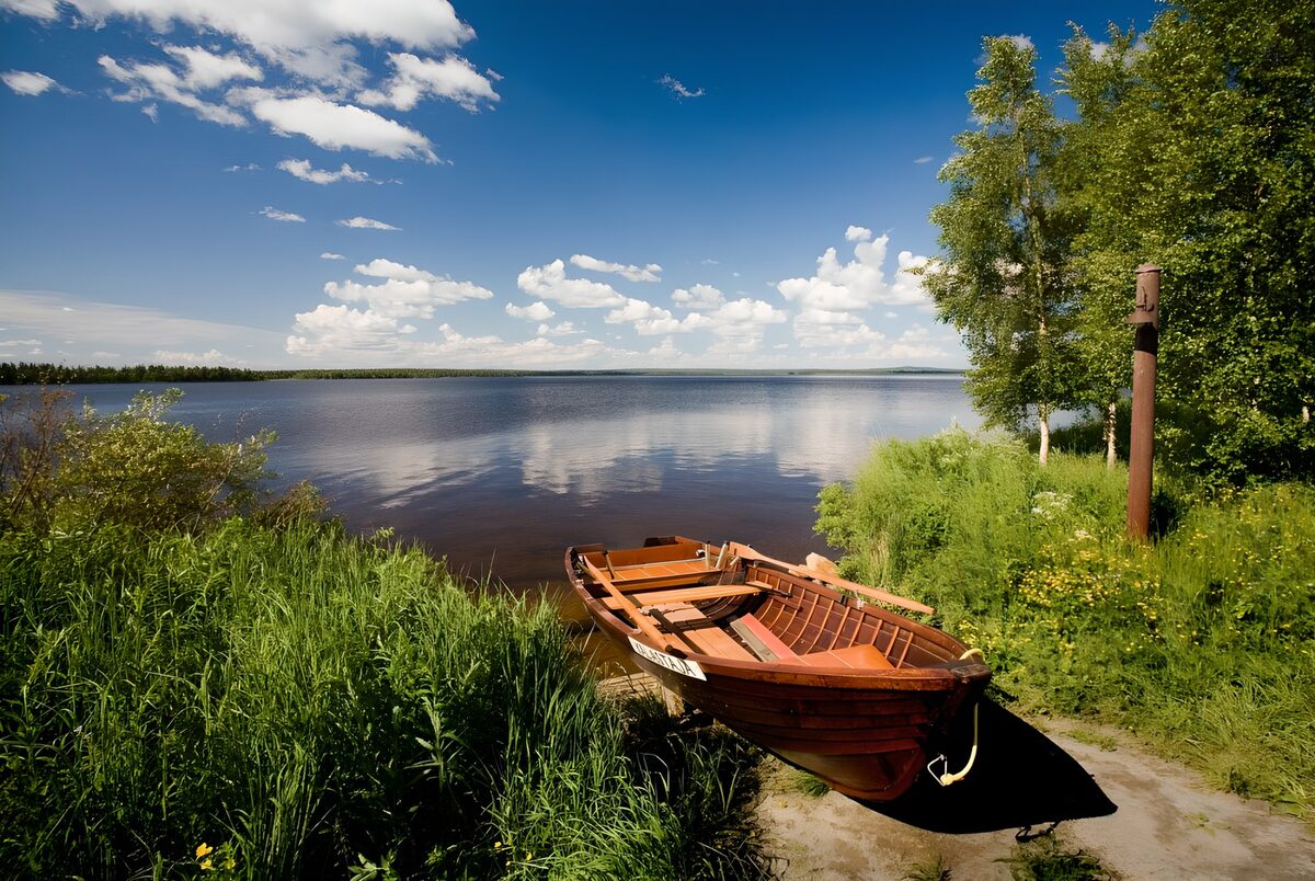 Wooden rowboat on a summer lakeshore