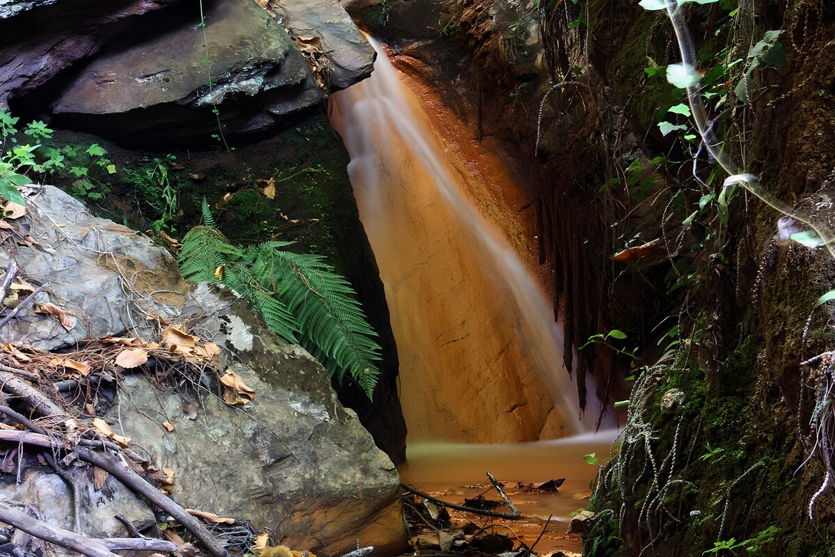 Secluded waterfall among dark rocks