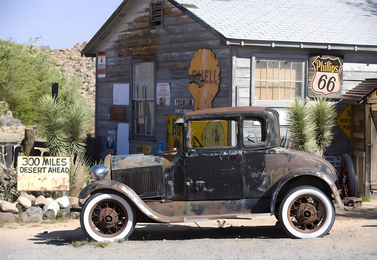 Rusty vintage car by a wooden building
