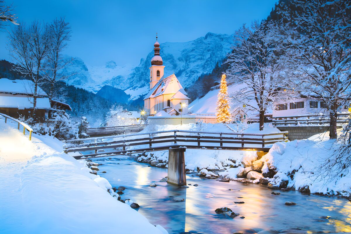 Snowy village church at blue twilight