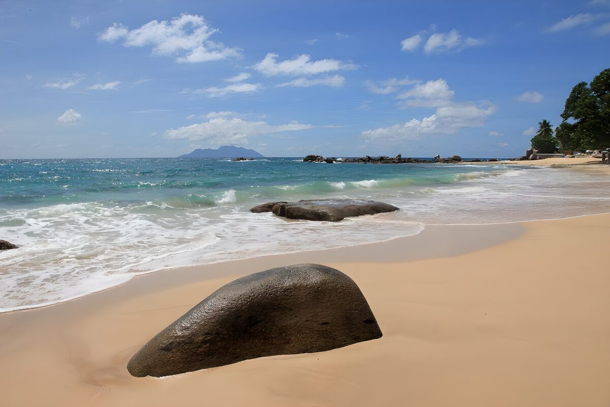 Sunlit beach with rocks and turquoise sea