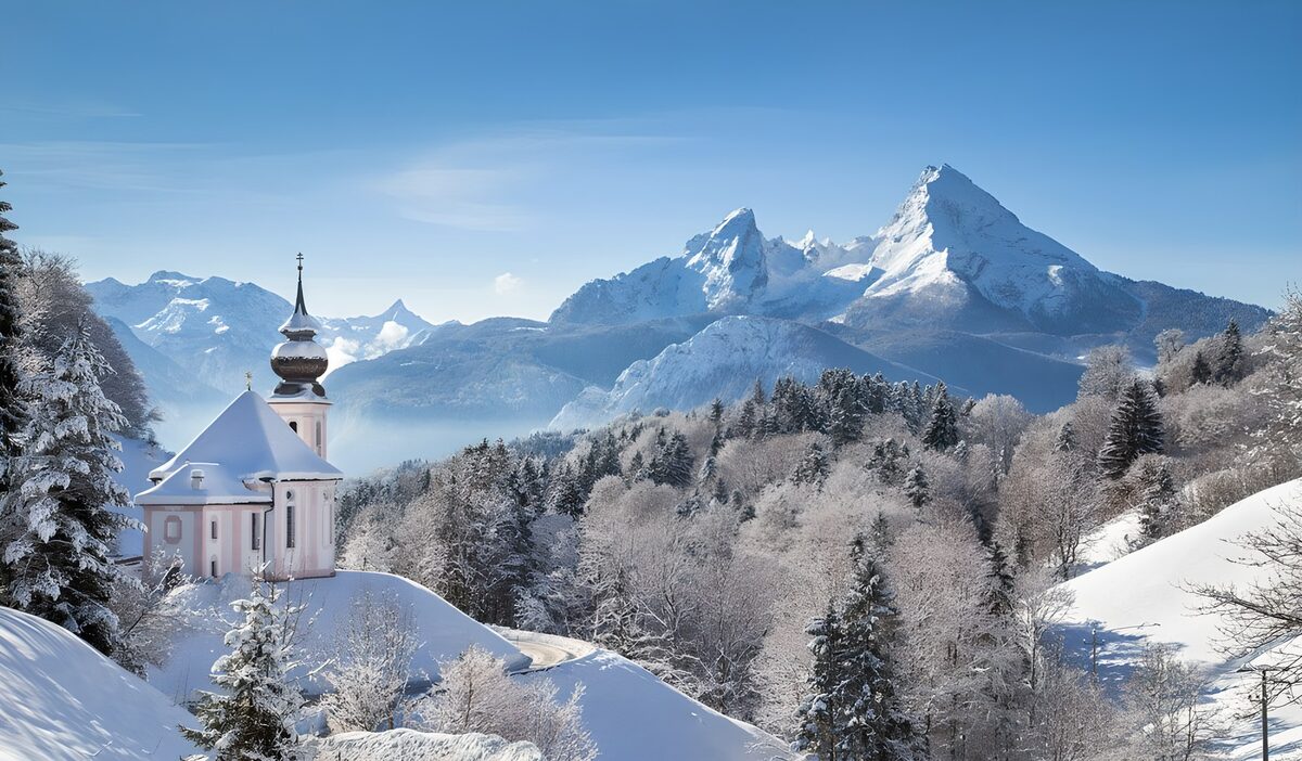 Snow-covered church beneath mountain peaks