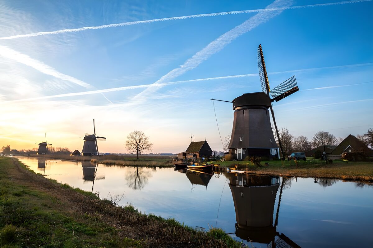 Windmills by a canal in soft golden light