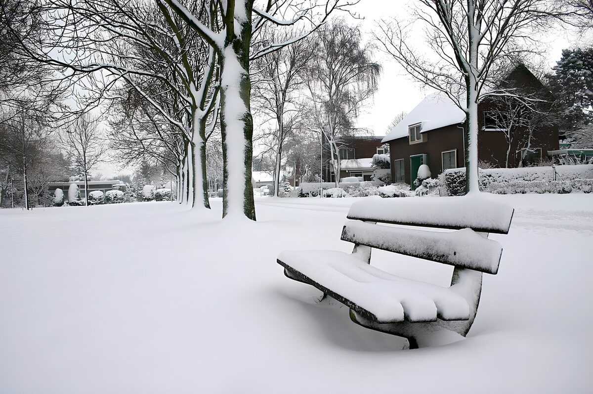 Snow-covered bench and quiet houses
