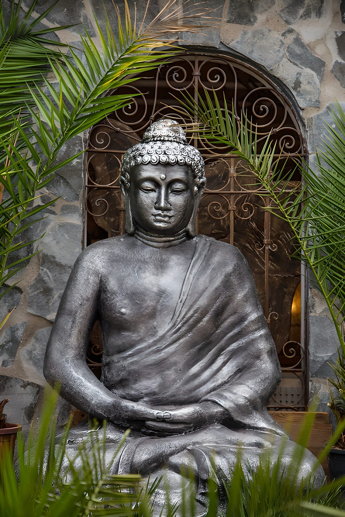 Buddha seated among palms in quiet light