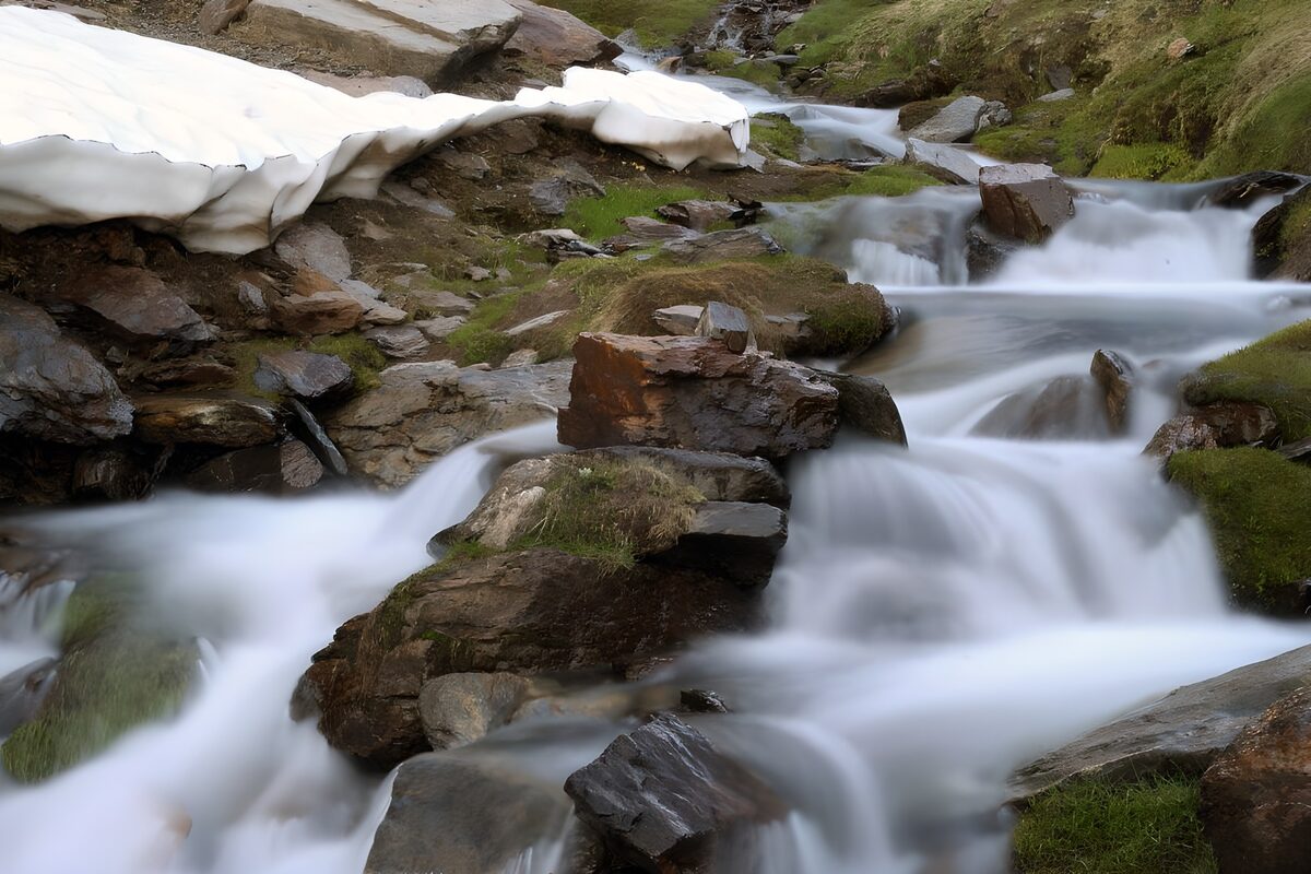 Rocky stream beside lingering snow