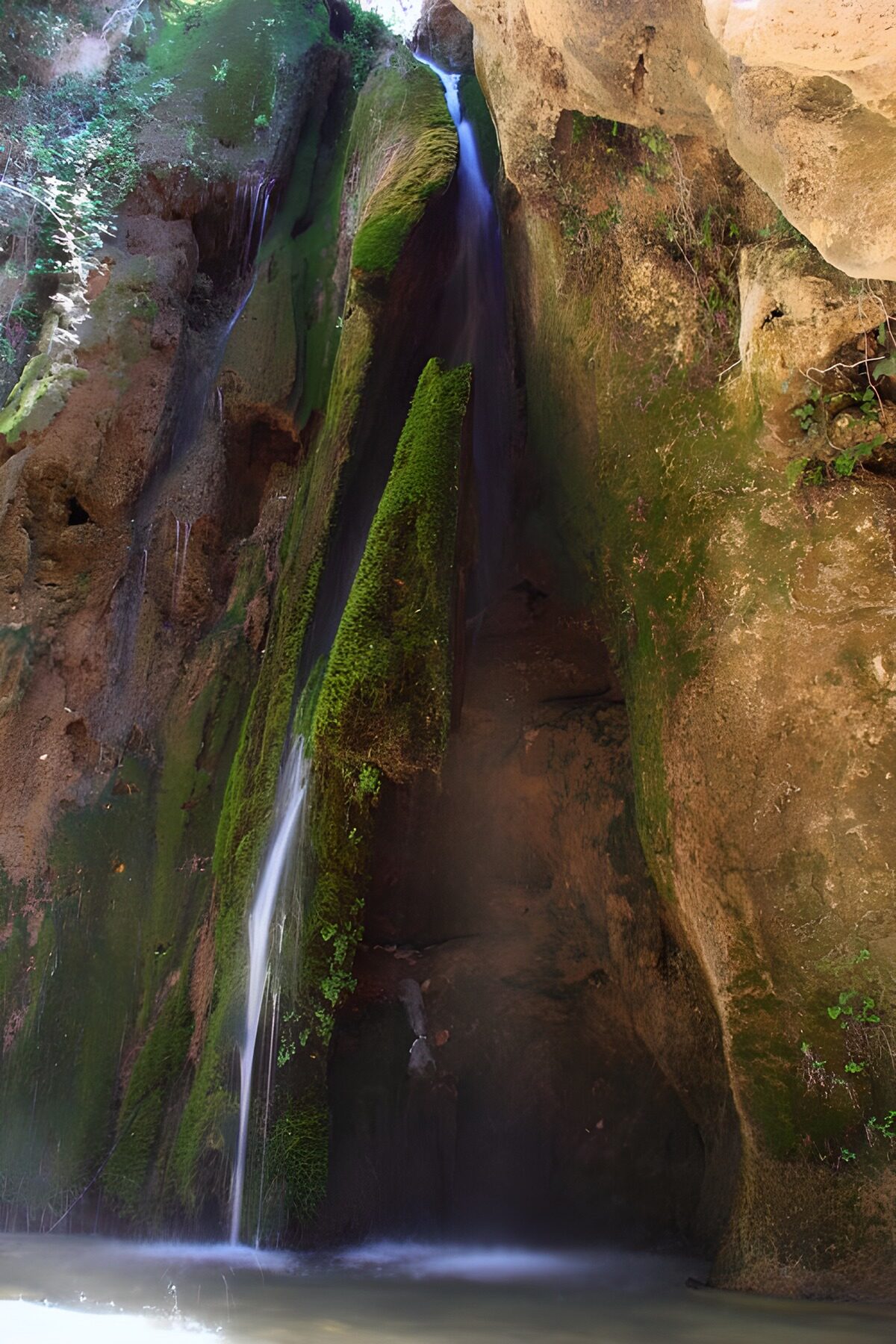 Waterfall in a sheltered, mossy gorge