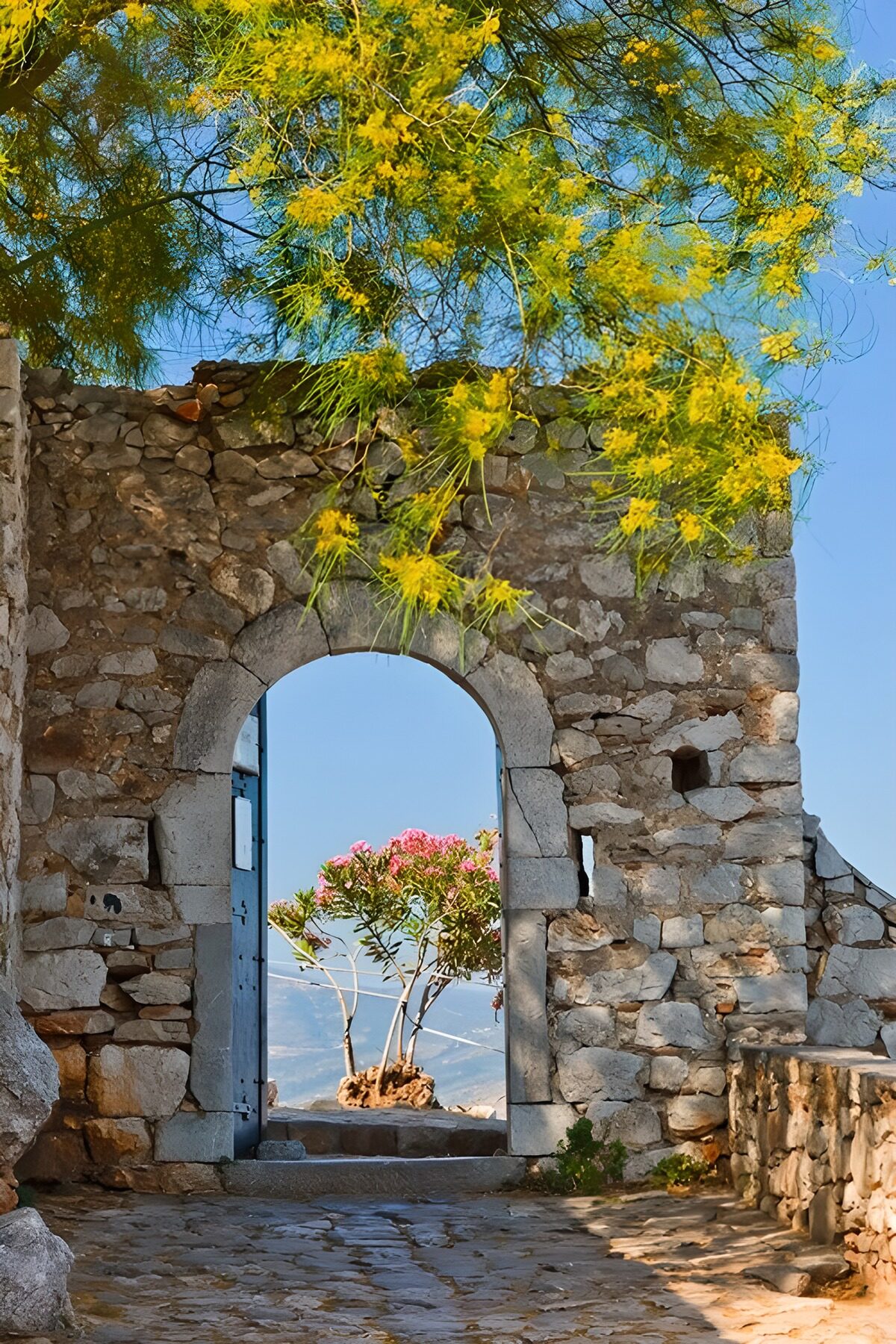 Sunlit stone arch with a mountain view