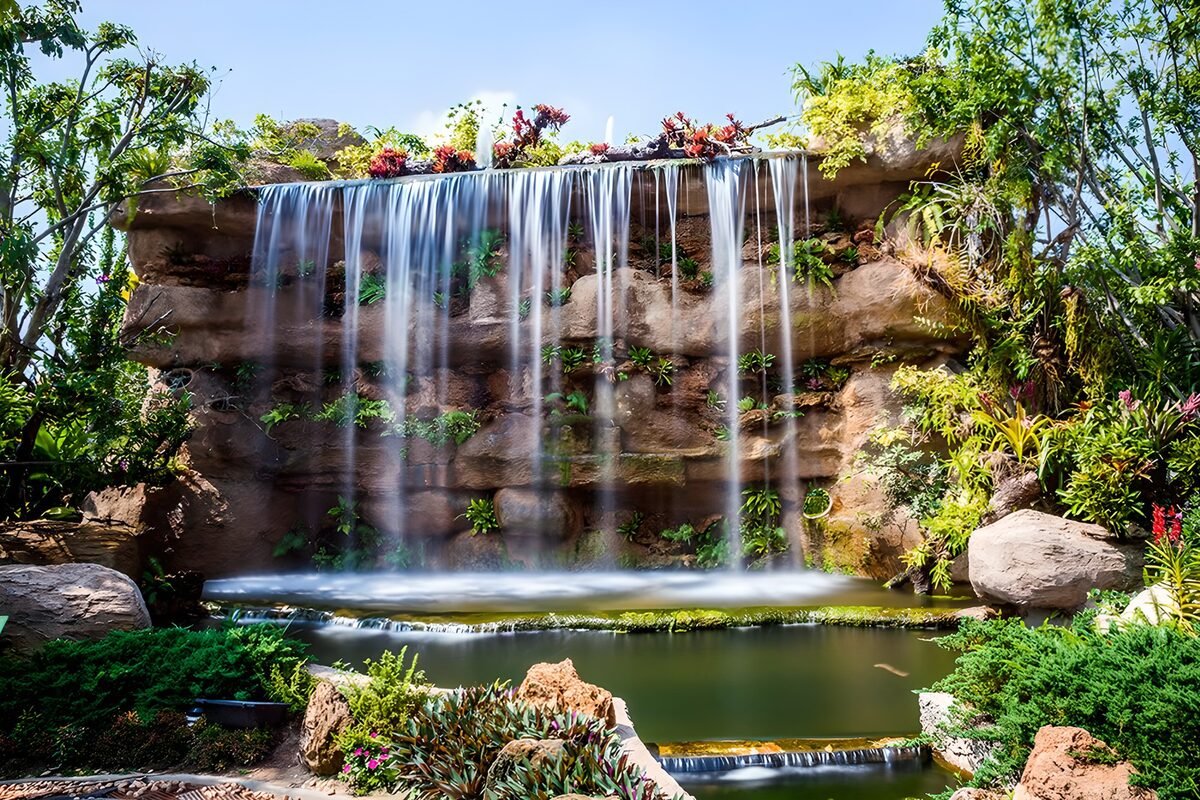 Garden waterfall over a broad rock wall