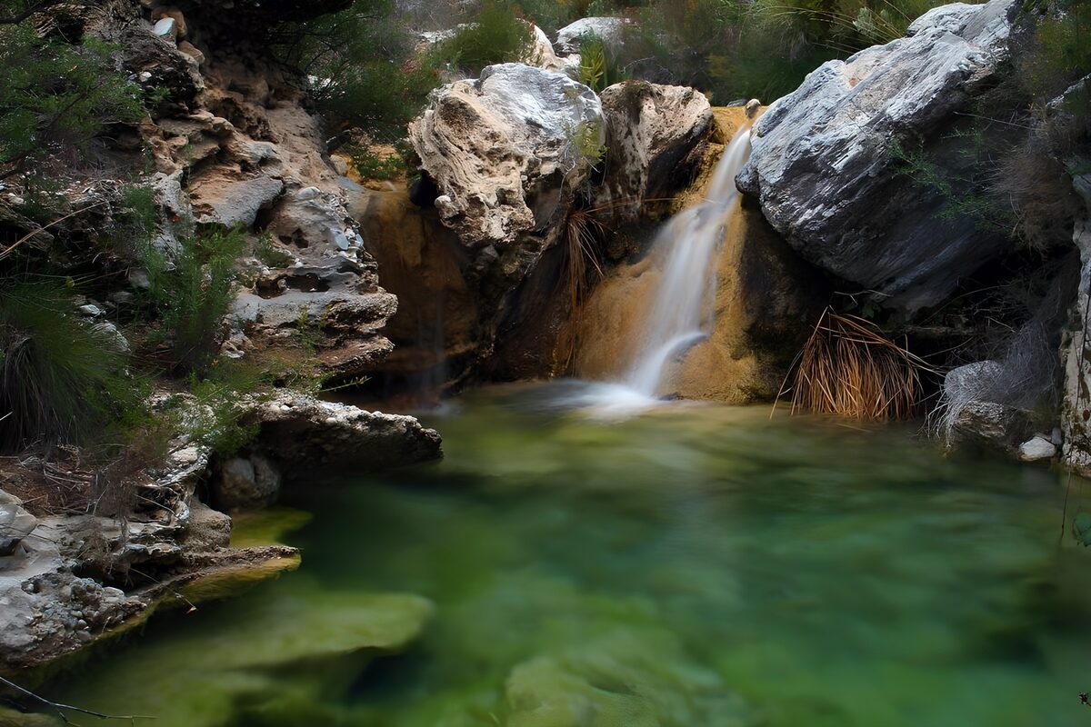 Small waterfall and a sheltered green pool