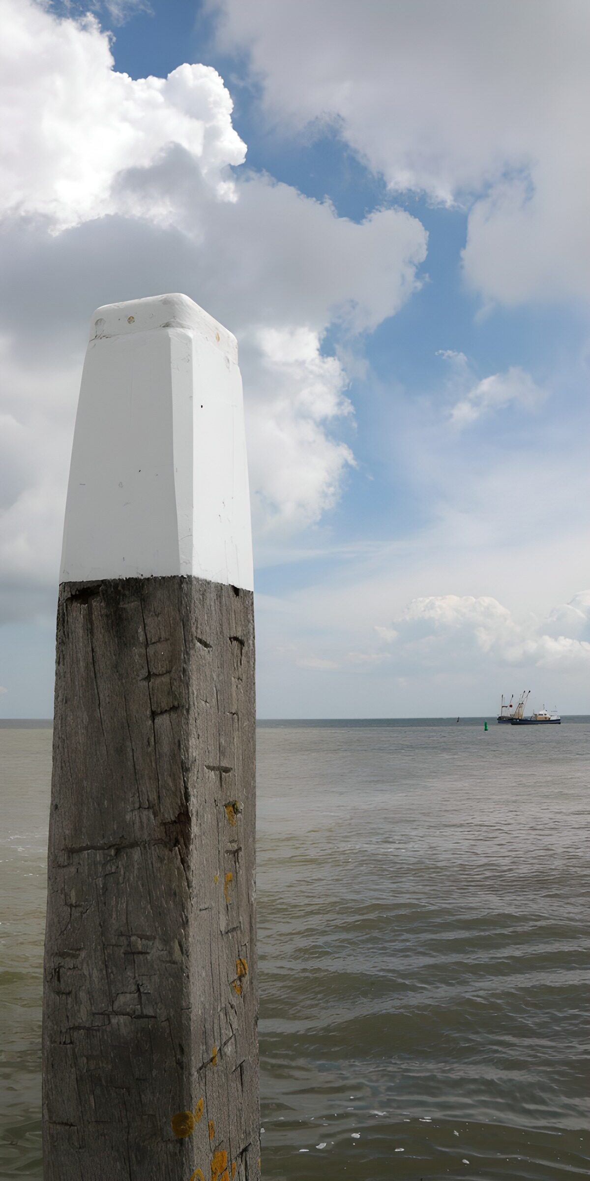 Weathered mooring post by a quiet sea