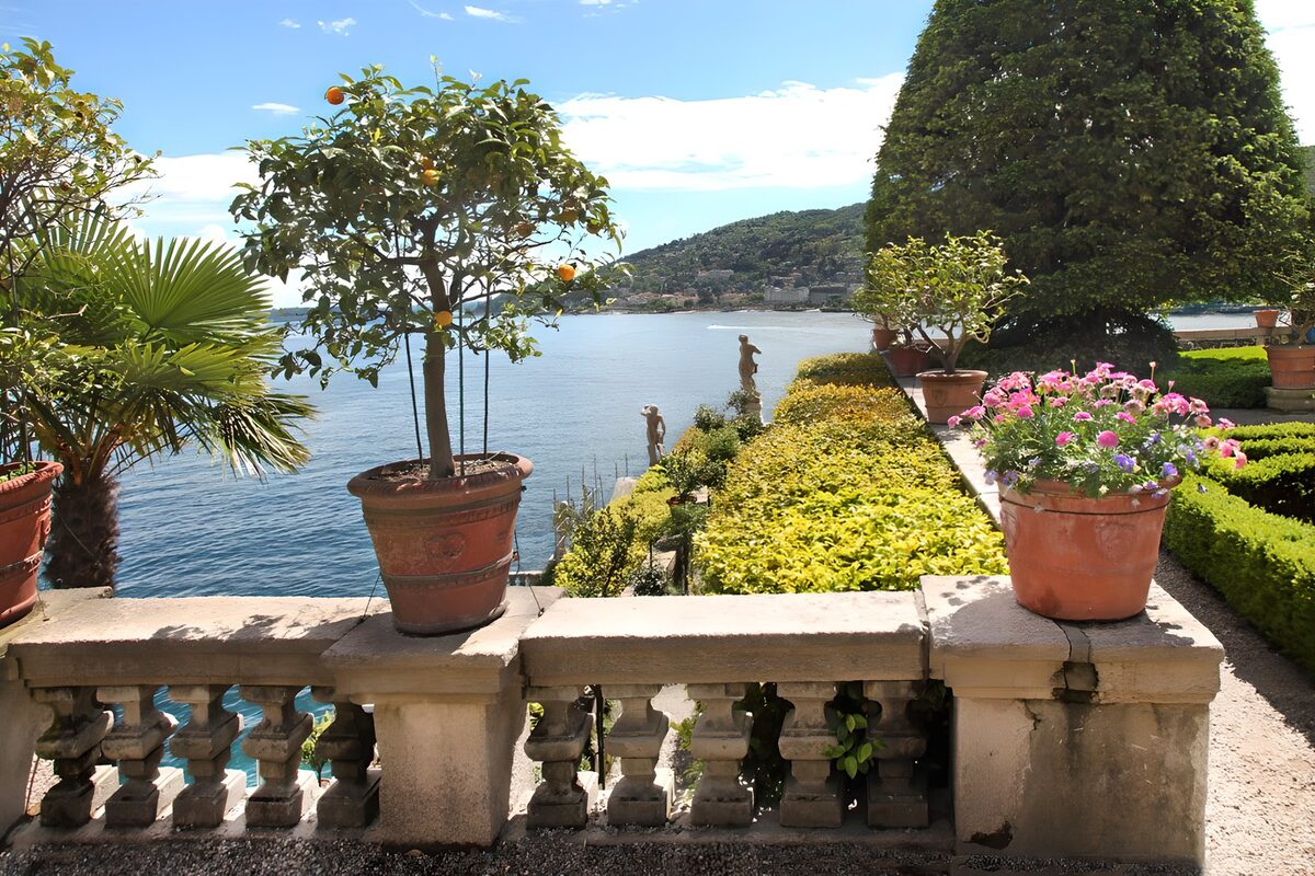 Sunlit garden terrace above blue water