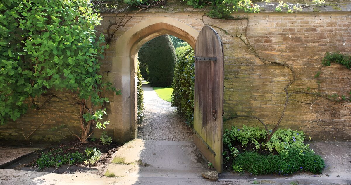 Open wooden door to a sunlit garden