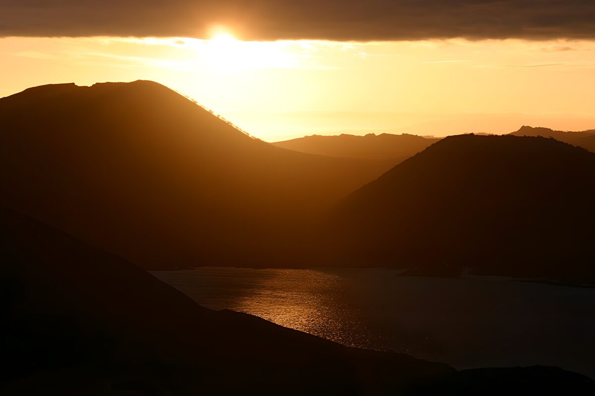 Mountain silhouettes and golden water