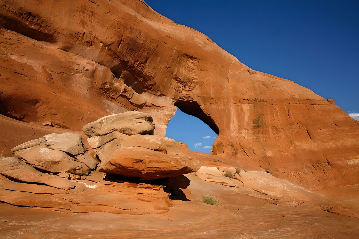Sunlit sandstone arch beneath a blue sky