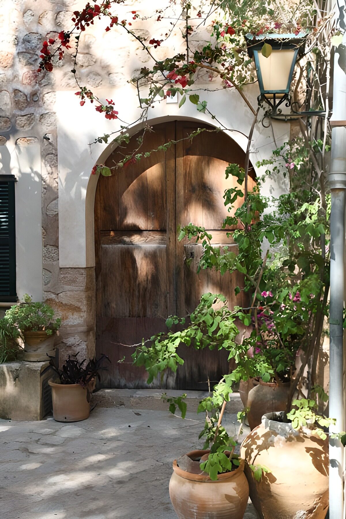 Sunlit arched door and terracotta pots