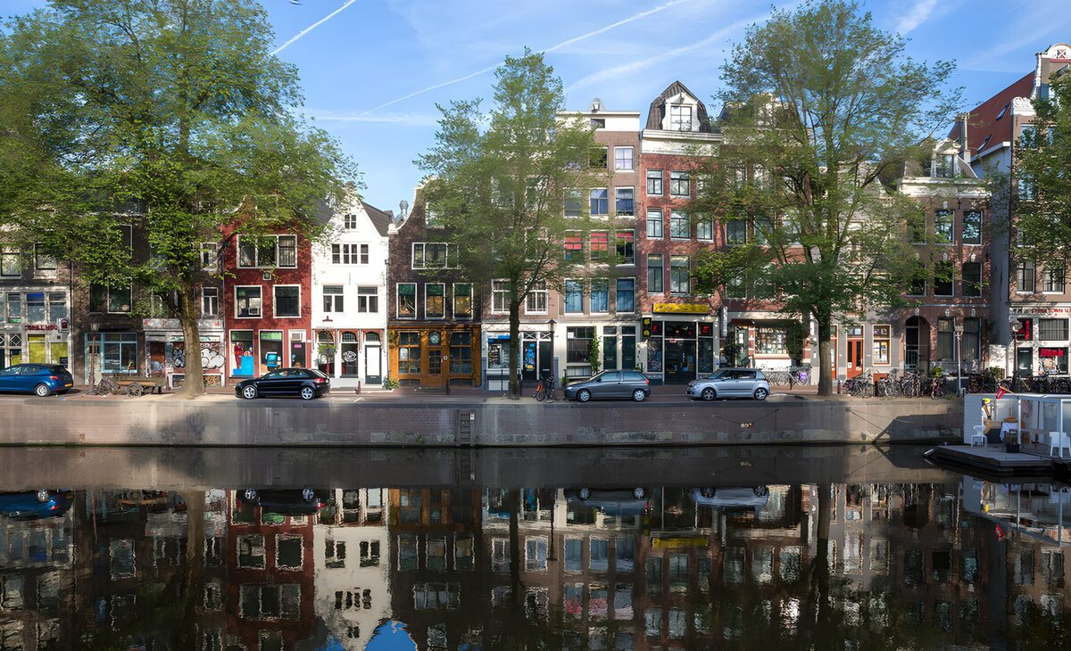 Sunlit canal houses and reflections