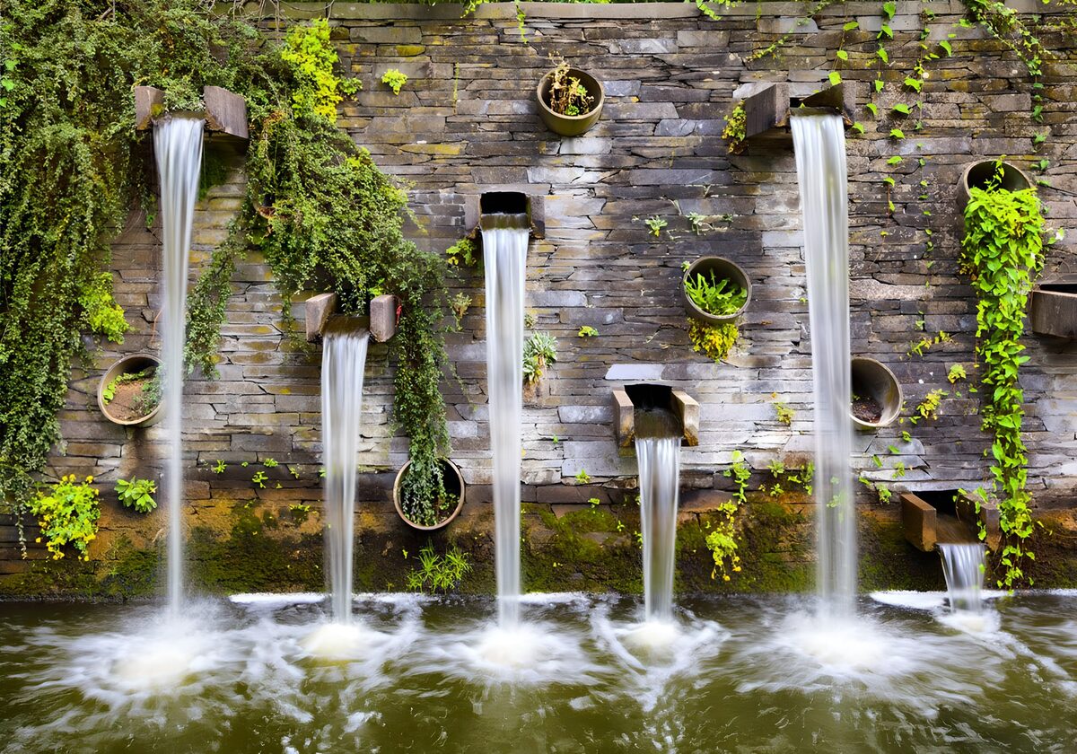 Stone water wall in a leafy garden