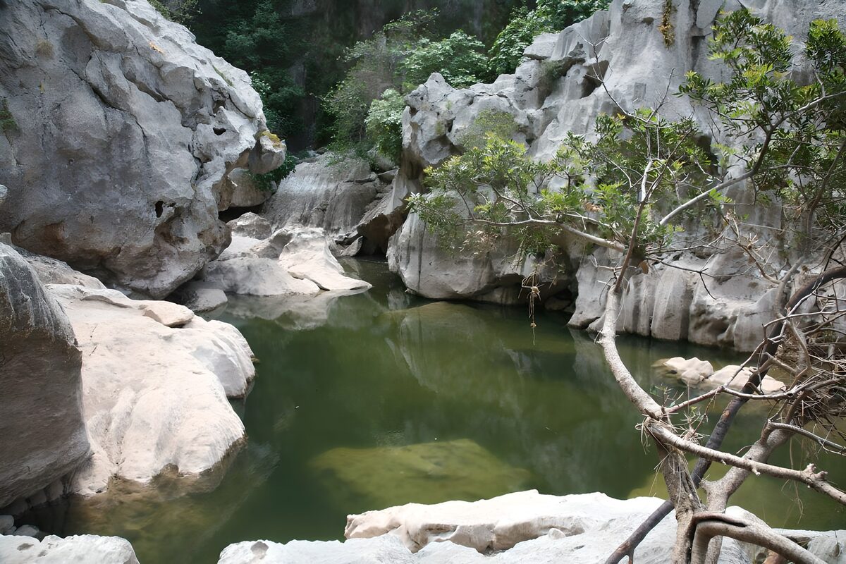 Still green pool between pale rocks