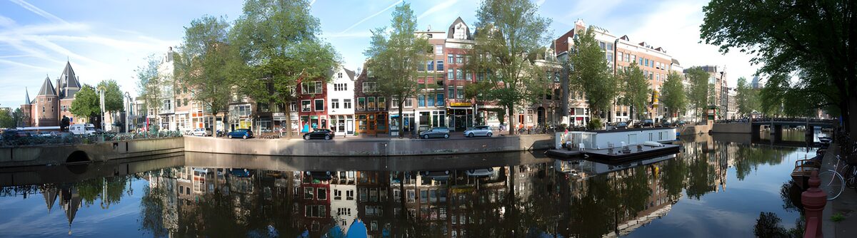 Sunlit canal houses and clear reflections