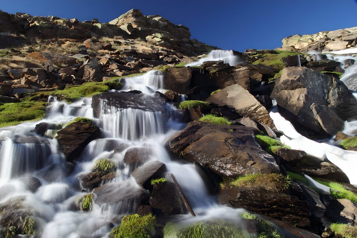 Mountain stream over sunlit rocks