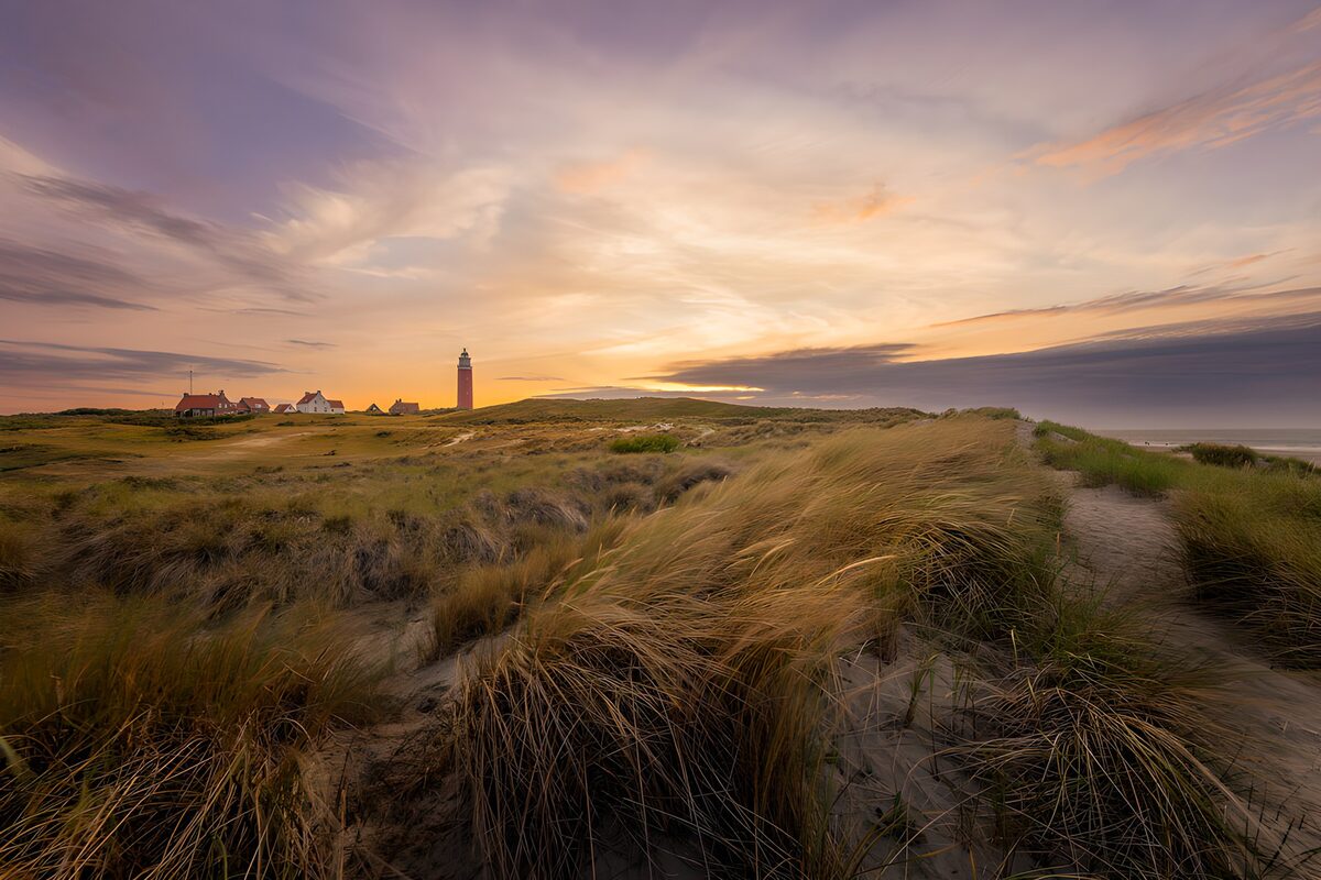 Lighthouse and dunes at sunset