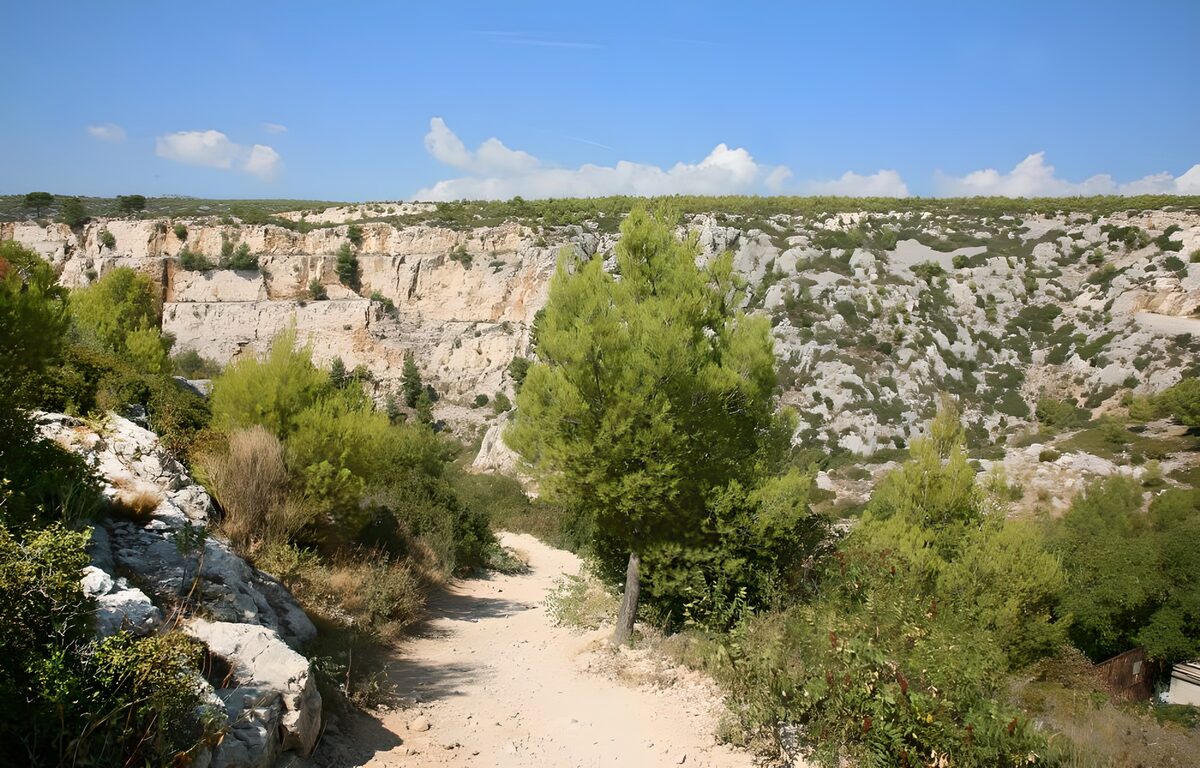 Sandy path beside a sunlit gorge