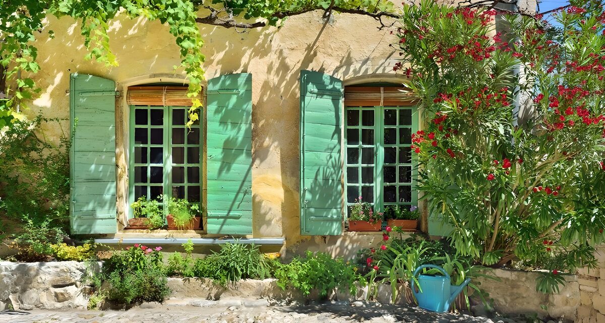 Green shutters on a sunlit yellow wall
