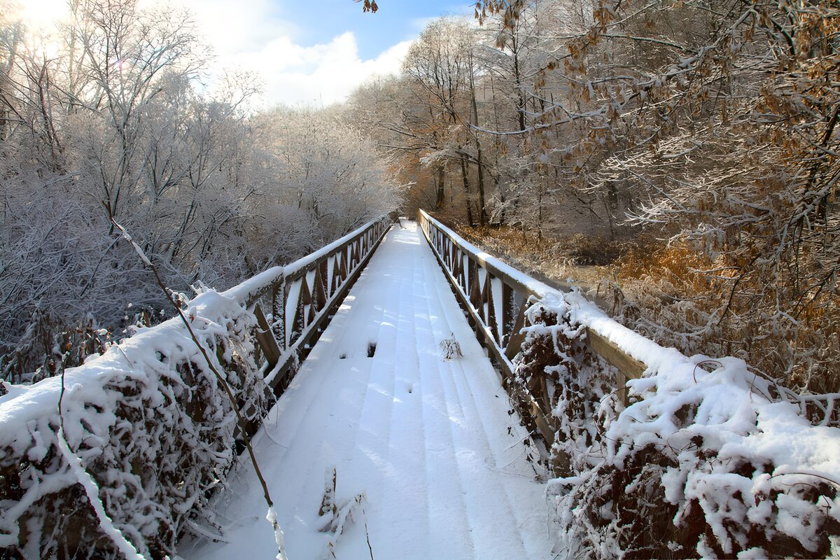 Snow-covered footbridge in winter light
