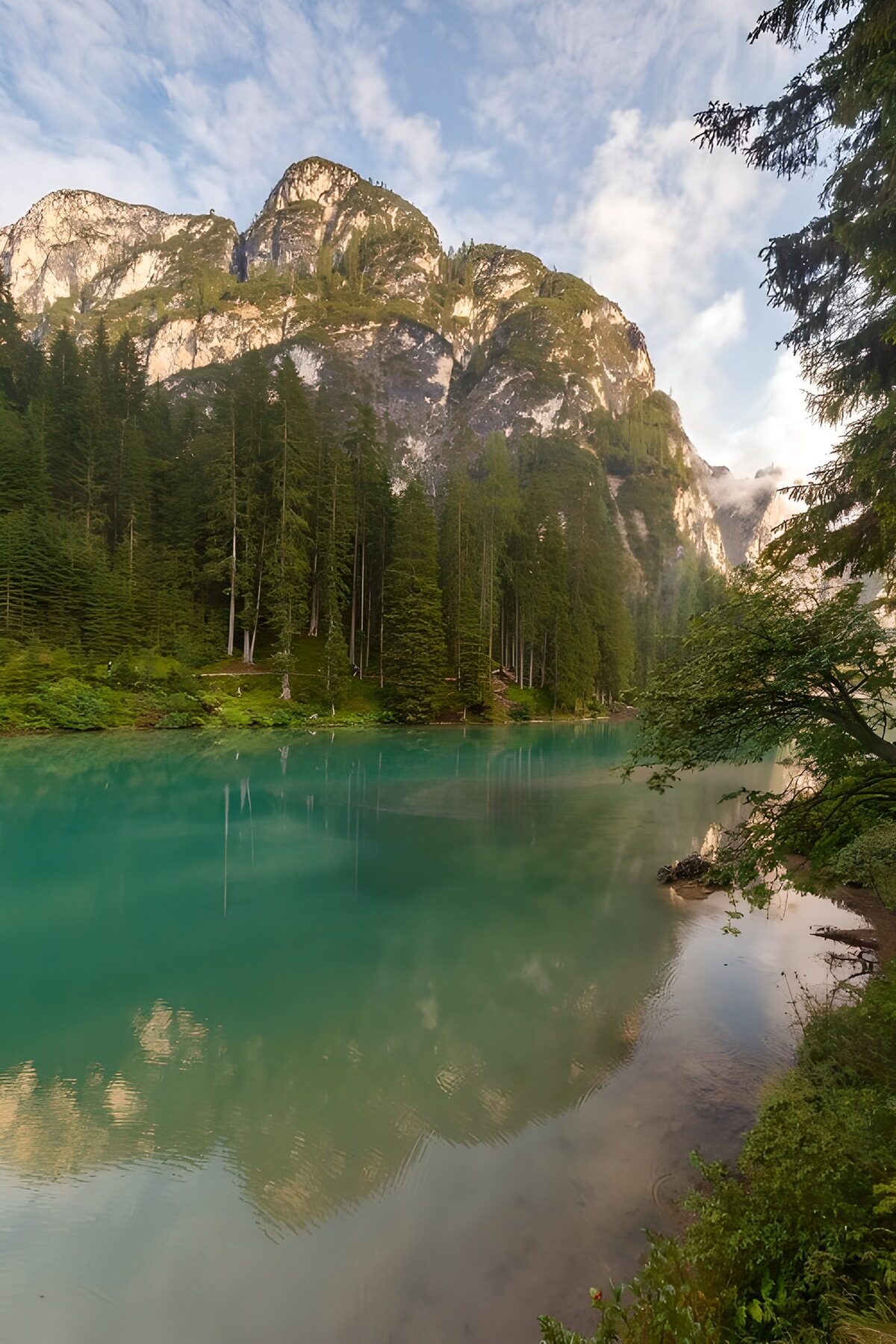 Still turquoise lake beneath pale cliffs