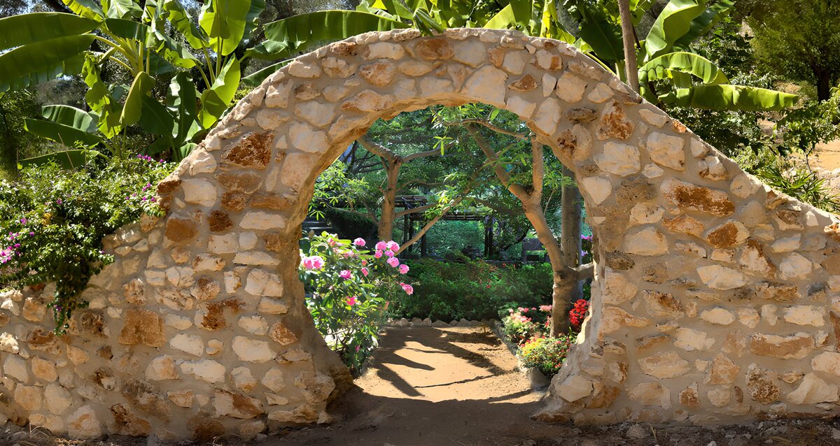 Sunlit stone arch into a leafy garden