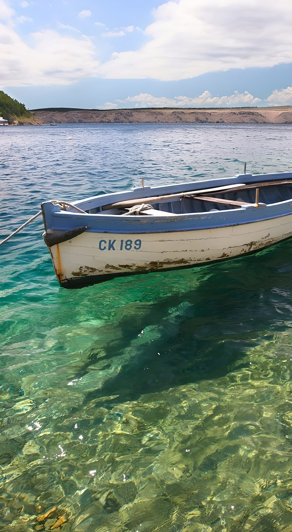 Weathered rowboat on clear turquoise water
