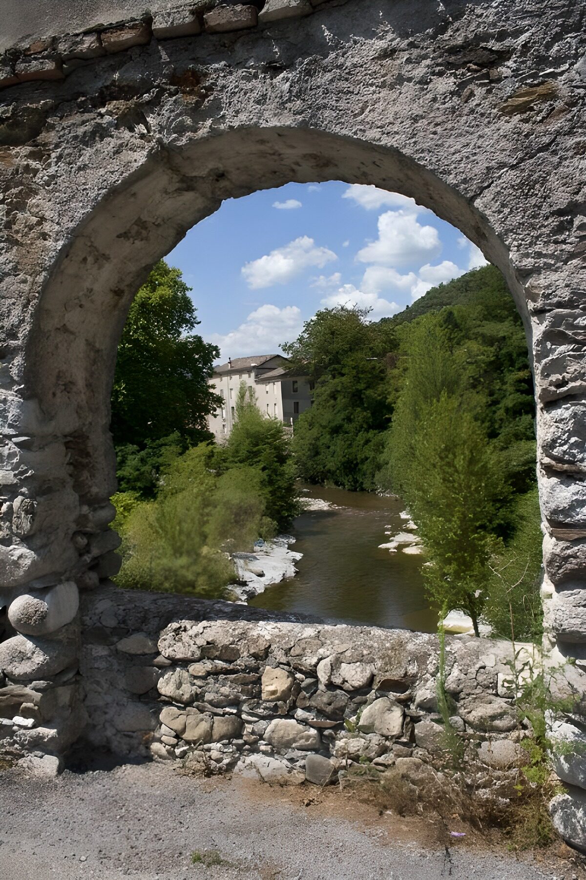 Sunlit river through an old stone arch