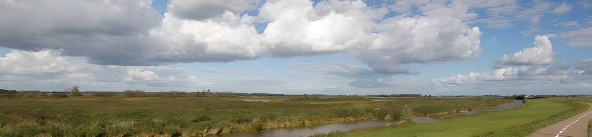 Wetland channel under wide, cloudy skies
