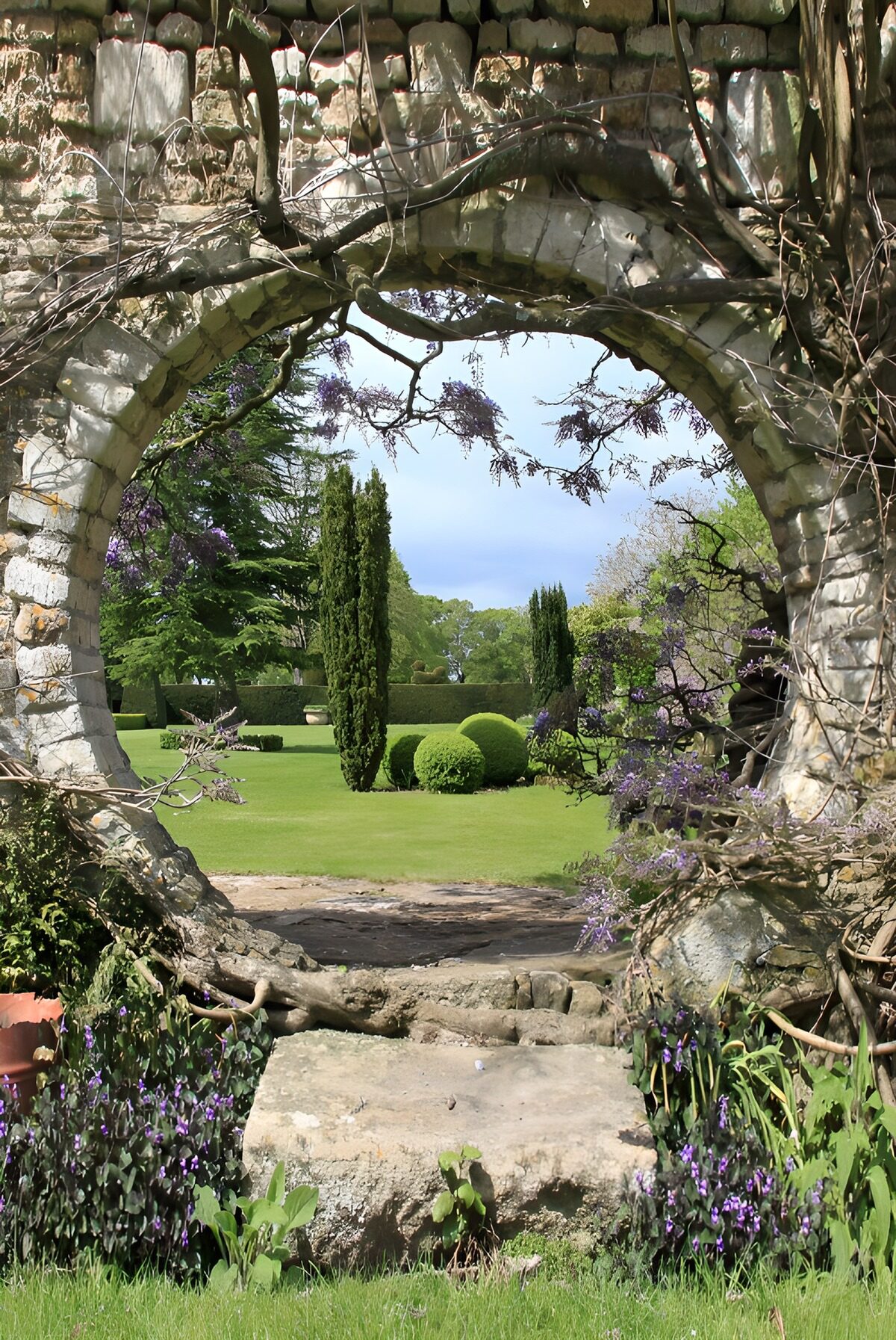 Stone arch overlooking a sunlit garden