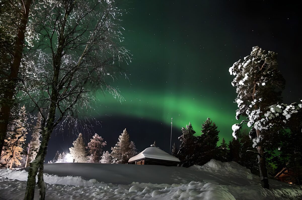 Snowy cabin beneath the northern lights