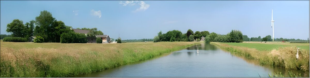 Summer canal with farms and a wind turbine