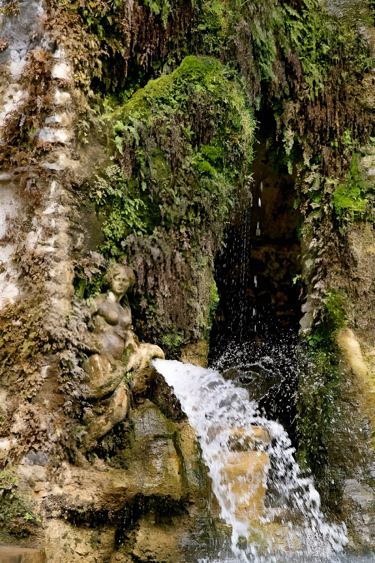 Stone figure at a moss-covered fountain