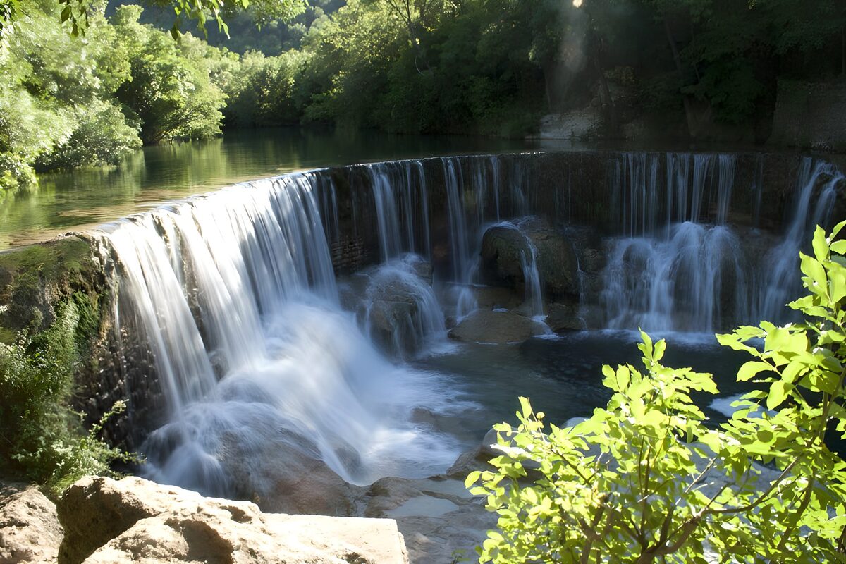 Woodland weir in sunlight