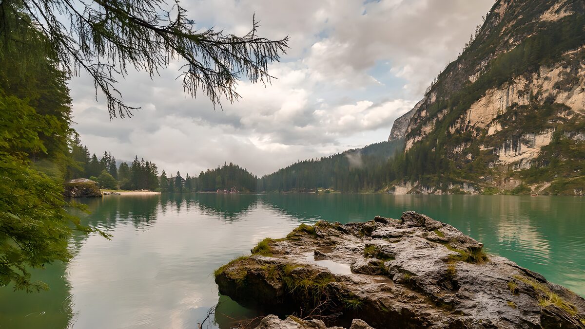 Green mountain lake beneath a pale cliff