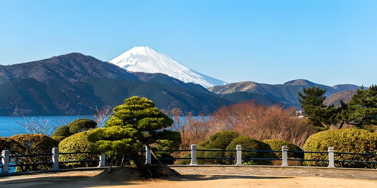 Snowy Mount Fuji above a lakeside garden