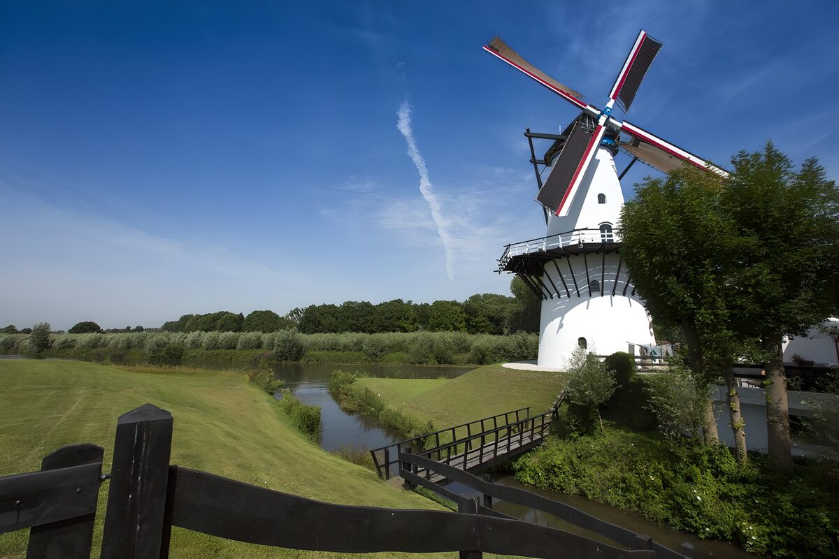 White windmill by a sunlit canal