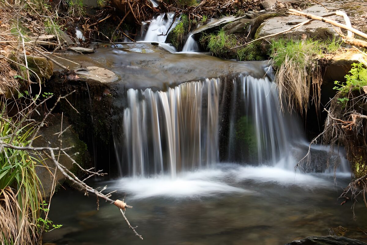 Soft cascades over a dark rock ledge