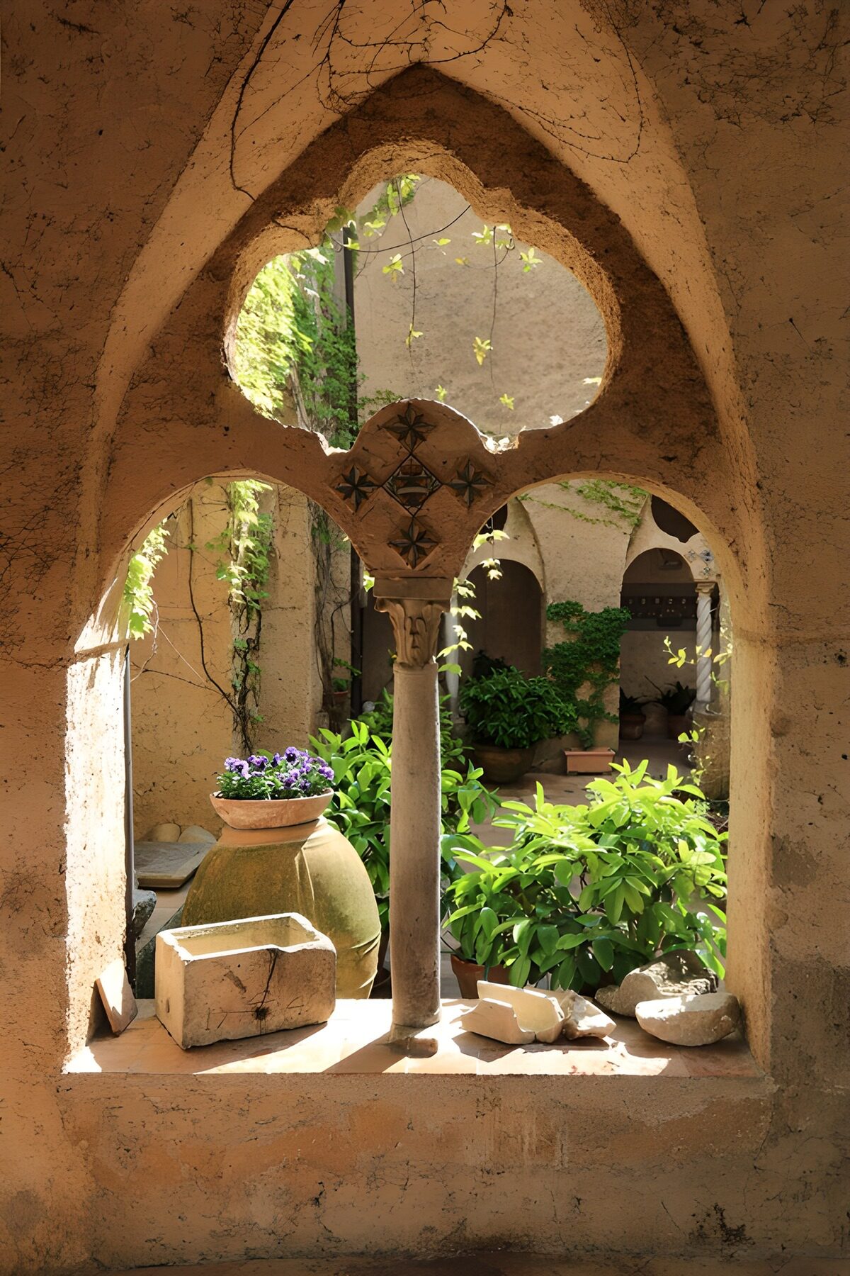 Sunlit courtyard through carved stone arches