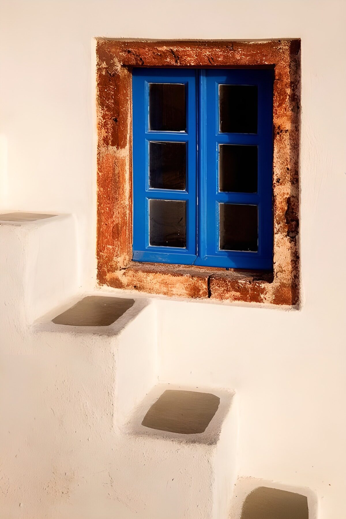 Blue window above sunlit white steps