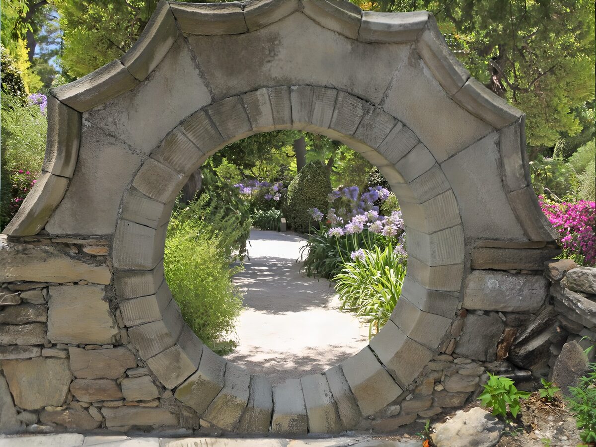Round stone opening onto a sunlit path