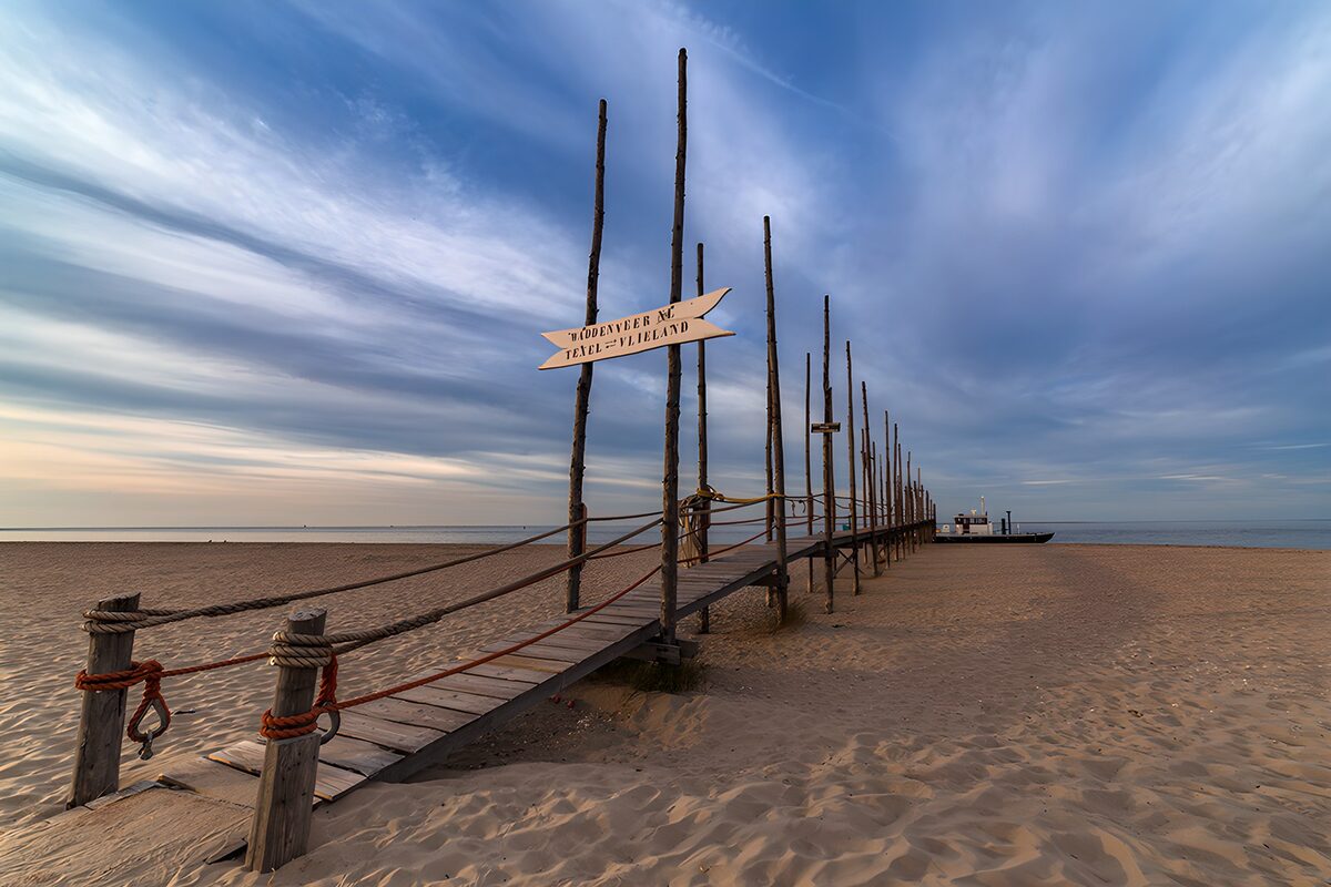 Wooden jetty on a beach at dusk