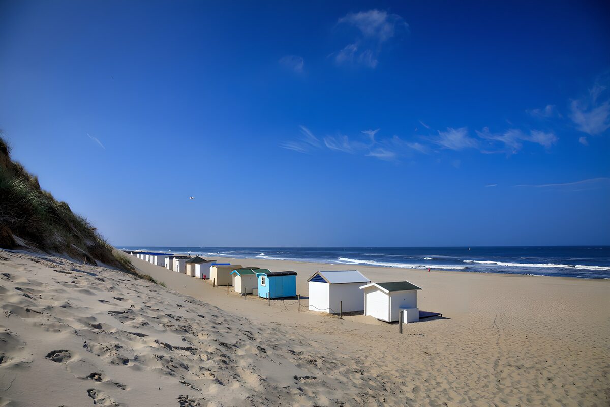 Beach huts on sunlit sand